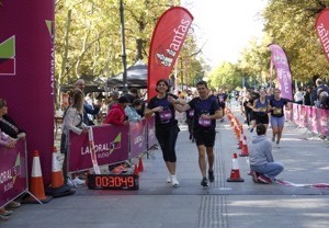 Corredores cruzando el arco de meta de una carrera popular