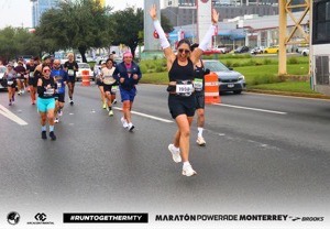 Corredora con los brazos en alto en una avenida
