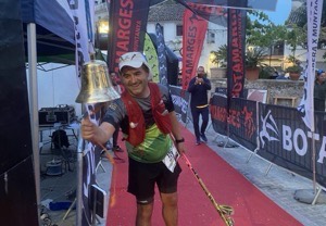 Corredor tocando la campana al terminar una prueba de trail